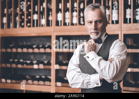 Sommelier Concept. Senior man standing touching chin smiling confident Stock Photo