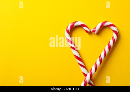 Sweet candy canes on yellow background, space for text Stock Photo