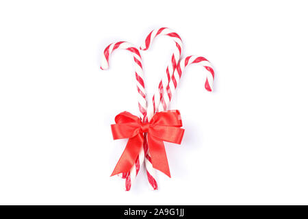 Sweet candy canes with bow isolated on white background Stock Photo