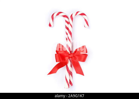 Sweet candy canes with bow isolated on white background Stock Photo