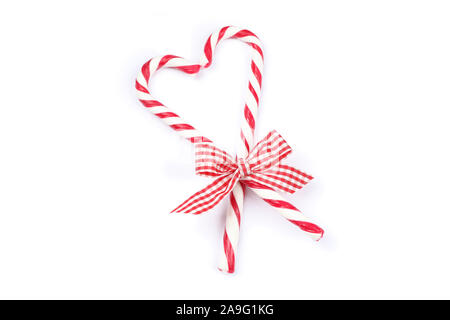 Sweet candy canes with bow isolated on white background Stock Photo