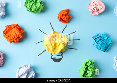 Light bulb and paper balls on blue background, top view Stock Photo