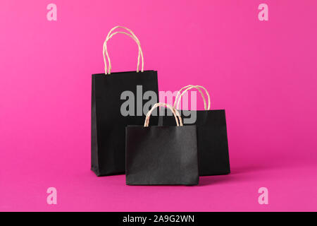 Small paper bags on pink background, space for text Stock Photo