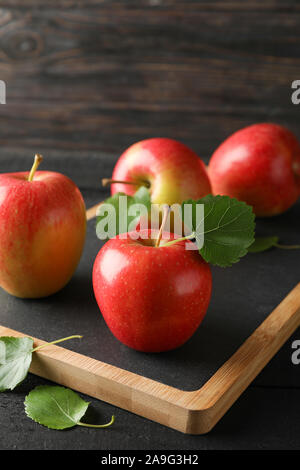 Apples and cutting board on wooden background, space for text Stock Photo