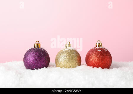 Glittering Christmas baubles on pink background, space for text Stock Photo