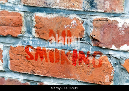 Hand painted No Smoking sign on a brick wall. Stock Photo