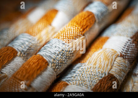 Stacked Knitted Plaid Background. Knitwear Blanket Fabric Texture with a Complex Square Interweaving. Stock Photo