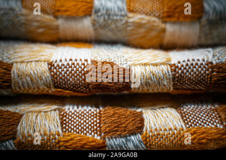 Stacked Knitted Plaid Background. Knitwear Blanket Fabric Texture with a Complex Square Interweaving. Stock Photo