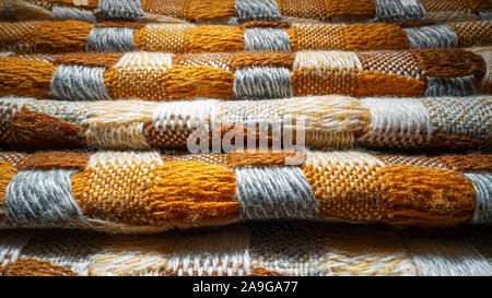 Stacked Knitted Plaid Background. Knitwear Blanket Fabric Texture with a Complex Square Interweaving. Stock Photo