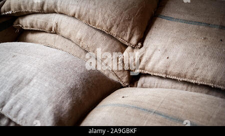 Hessian Sacks. Full frame detail from within a warehouse packaging their goods in woven canvas sacks. Stock Photo