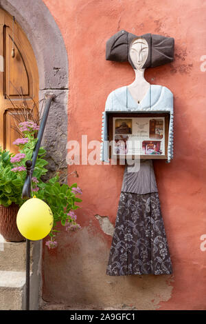 A carved wooden model of a woman  used as an advert for a gite holiday accommodation in Eguisheim Alsace France Europe Stock Photo