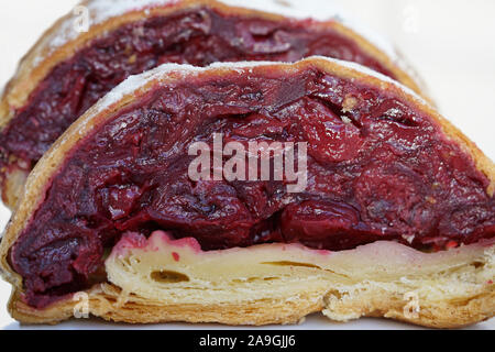 Appetizing slices of cherry strudel is a delicious and dainty dessert, close up and on white background, isolated Stock Photo