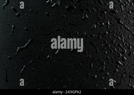 macro background of black flat rubber surface with water drops. Stock Photo