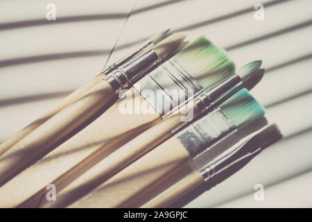 Set of used different brushes for painting on the table. Stock Photo