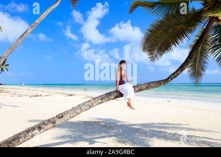 Frau sitzt auf Palme, Sansibar, Afrika Stock Photo