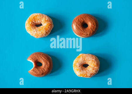 Sugar coated donuts and donuts with chocolate frosting with one donut bitten Stock Photo