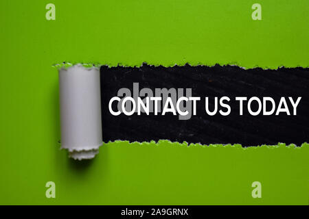 Contact Us Today Text written in torn paper Stock Photo