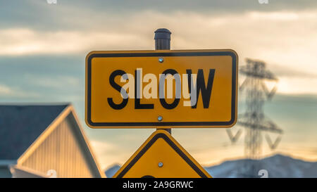 Panorama frame Pedestrian crossing road sign against houses vehicles mountain and cloudy sky Stock Photo