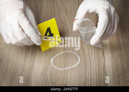 Forensic officer collecting a bullet casing as a piece of evidence Stock Photo