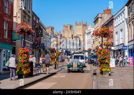 The towers of Wells Cathedral from High Street Wells with Classic car in foreground Stock Photo