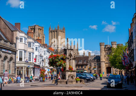 The towers of Wells Cathedral from the market place with the well in the foreground Stock Photo