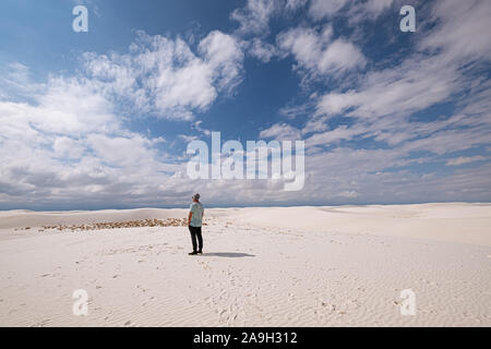 man in casual clothing amidst white sand dunes against blue sky Stock Photo