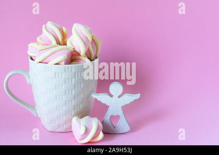 White cup of chocolate with pink marshmallows on a pink background. Copy space. Stock Photo