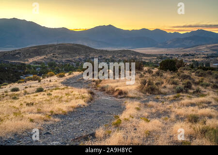 Hiking trail winding through Utah Valley near homes Stock Photo