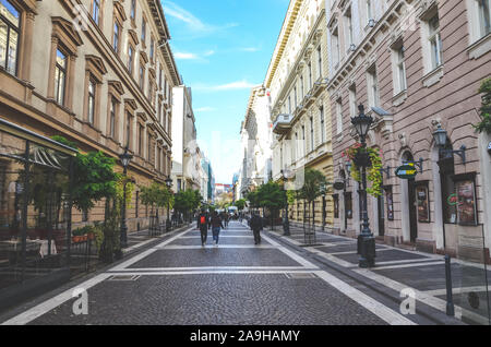 Budapest, Hungary - Nov 6, 2019: Zrinyi street in the historical center of the Hungarian capital. Pedestrian zone leading from the famous St. Stephens Basilica. Restaurants, people walking. Stock Photo