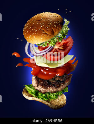 Flying burger with sesame seeds, green salad, ketchup, tomato slices and onions on a blue background. Stock Photo