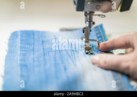 Sewing machine operator sew on a machine. Close-up depicts sewing equipment. Horizontal image Stock Photo