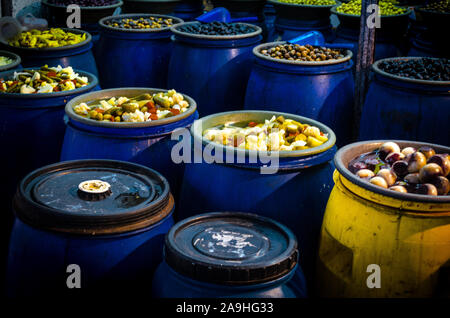 Blue barrels containing picklets, fruits, olives, cucumbers, little onions and other vegetables in a street market in Santiago de Chile Stock Photo