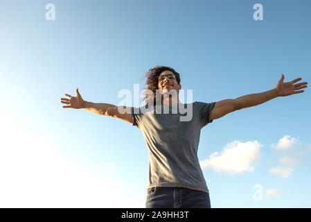 Young Latin man with arms outstretched Stock Photo