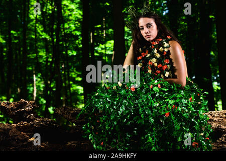 Outdoor high fashion of woman in dress made of leaves and roses Stock Photo