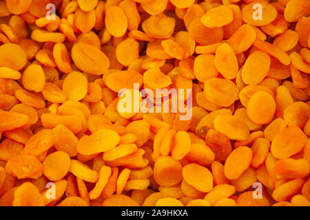 little round orange dried pieces of apricot fruit in a bin Stock Photo