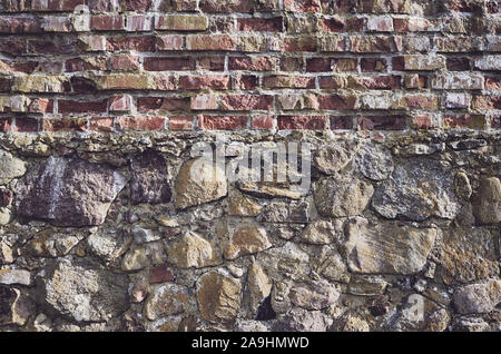 Ancient wall made of bricks and stones. Stock Photo