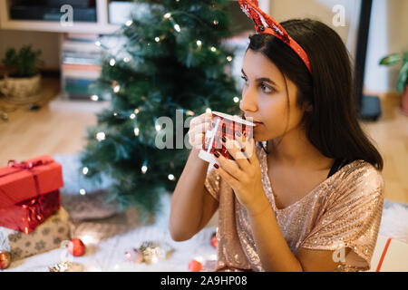 Girl with deer headband drinking hot drink Stock Photo