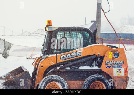 Moscow, Russia - March 5, 2018: Yellow tractor with snowplow removing snow during heavy snowfall. Winter street Stock Photo