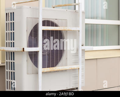 Air conditioning compressor on the outside wall of the house next to the window Stock Photo