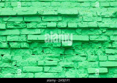 Green brick background texture of old brick masonry with elements of destruction, painted in green color Stock Photo