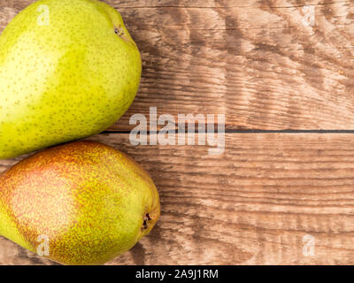 Two large juicy pears, green and red-green, on aged wooden table, top view Stock Photo