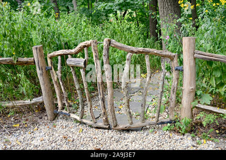 Unique rustic wood gate made to look like a part of nature. Closeup. Stock Photo