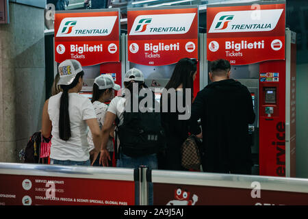 Italy, Milan, July 12, 2019: People buy tickets at self-service machines at the train station in Milan. Stock Photo