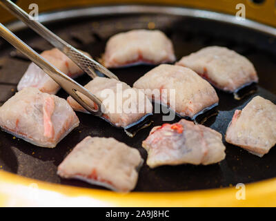 Close up of freshwater eel / unagi being grilled on a traditional Korean / Chinese / Asian style grill Stock Photo