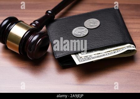 Black Leather Pocket With Banknotes And Coins Near Judge Gavel Over Wooden Desk Stock Photo