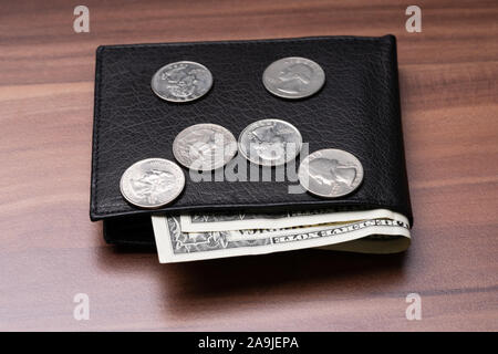 Close-up Of Black Leather Pocket With Banknotes And Coins Over Wooden Table Stock Photo