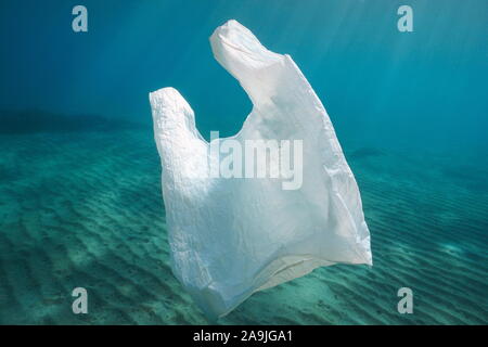 Plastic pollution, a white plastic bag underwater in the ocean Stock Photo