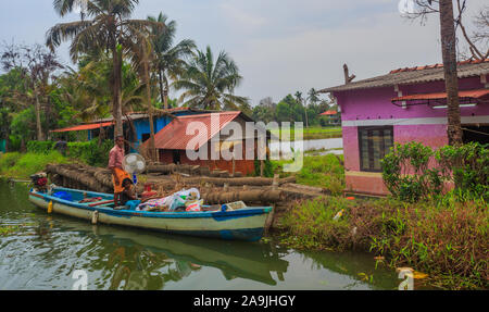 A villager transporting stuffs in a wooden boat in Alleppey area (Kerala, India) Stock Photo