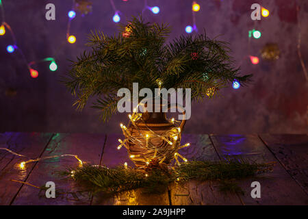 Vase with spruce branches stands on the table. Stock Photo