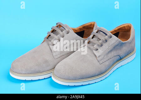 Pair of modern gray man shoes side view isolated on blue background Stock Photo